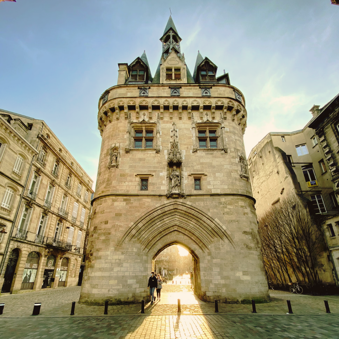 An image of Porte Cailh, an old stone gateway surrounded by walkway and buildings.